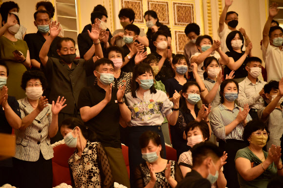 3일 북한 평양의 삼지연극장에서 마스크를 쓴 주민들이 국무위원회 연주단의 공연을 관람하면서 박수를 치고 있다. AFP 연합뉴스