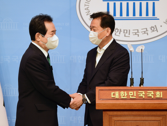 민주당 대선 경선 후보인 정세균 전 국무총리와 이광재 의원이 5일 국회 소통관에서 기자회견을 열고 정세균 전 총리로 후보 단일화 합의를 밝힌 뒤 악수를 나누고 있다.2021. 7. 5 김명국 선임기자 daunso@seoul.co.kr