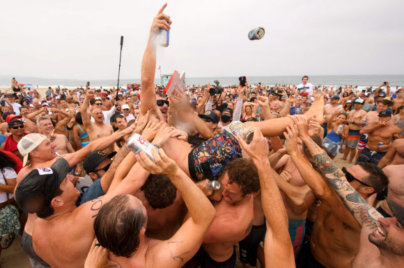 제47회 헤르모사 비치 아이언맨 대회에서 우승한 챔피언 셰인 갈라스가 4일(현지시간) 미국 캘리포니아 헤르모사비치에서 헹가래를 받고 있다. 40년 넘게 열린 이 비정규 3종 경기는 지난해 코로나19 대유행으로 취소된 뒤, 4일 재개됐다. 경쟁자들은 1마일을 달리고, 1마일을 서핑보드를 노를 젓고, 맥주 6팩을 마셔야 한다. 맥주를 토하는 사람들은 실격되지만, 누가 가장 잘 토하는가를 경쟁하는 사람들도 있다. AFP 연합뉴스