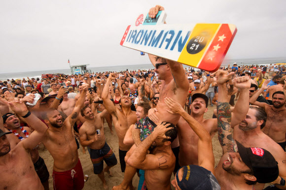 Champion Shane Gallas is lifted into the air after winning the 47th annual Hermosa Beach Ironman competition where participants must run a mile, paddle a surfboard a mile, and chug a six-pack of beer on July 4, 2021 in Hermosa Beach, California. - The unconventional triathlon held for over 40 years returns for the Fourth of July holiday after being cancelled last year due to the Covid-19 pandemic. Competitors run a mile, paddle a surfboard a mile, and chug a six pack of beer - those who puke their beer up are disqualified but some intentionally vomit to see who can puke the best. (Photo by Patrick T. FALLON / AFP)/2021-07-05 05:17:59/ <연합뉴스