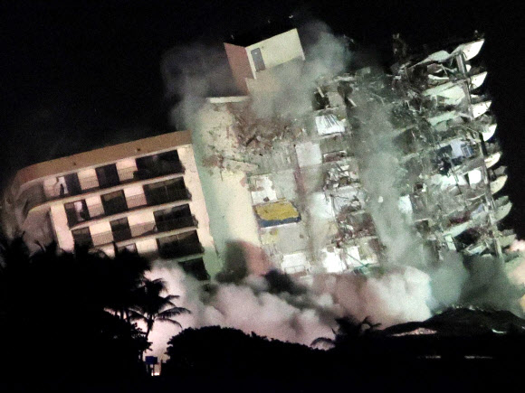 지난달 24일(이하 현지시간) 미국 플로리다주 서프사이드의 12층 아파트 일부가 무너져 참사가 빚어진 지 열하루가 된 4일 늦은 밤 남은 건물도 폭파 해체되고 있다. 서프사이드 AP 연합뉴스