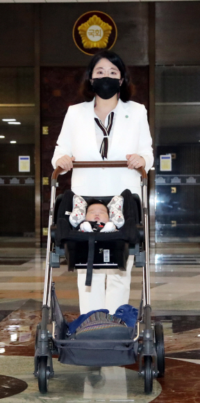 기본소득당 용혜인 의원이 5일 출산 후 처음으로 국회에 출근해 아기와 함께 본회의장을 지나가고 있다. 김명국 선임기자 daunso@seoul.co.kr