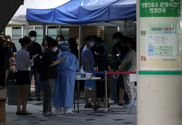 6일 오후 서울 마포구 보건소 코로나19 선별진료소에 시민들이 검사를 기다리고 있다. 이날 0시부터 오후 6시까지 전국 코로나19 신규 확진자가 총 1천6명이다. 2021.7.6  연합뉴스