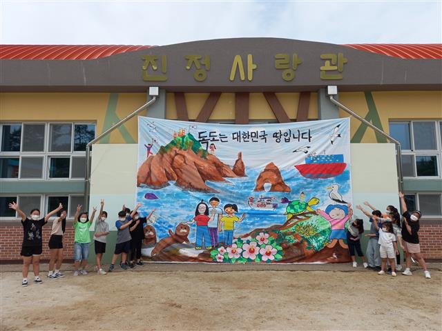 경남 하동군 금남면 진정초등학교 학생들이 ‘독도는 대한민국 땅입니다’ 대형 걸개그림을 체육관 벽에 건 뒤 포즈를 취하고 있다. 진정초 제공