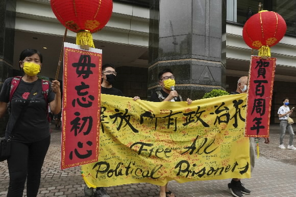 주권 반환 24주년인 7월 1일 경찰 1만여명이 시 전역에 배치된 홍콩에서 한 시위자가 ‘초심을 잊지 마라’는 팻말을 들고 ‘모든 정치범을 석방하라’는 현수막을 펼치고 구호를 외치고 있다. 홍콩 AP 연합뉴스