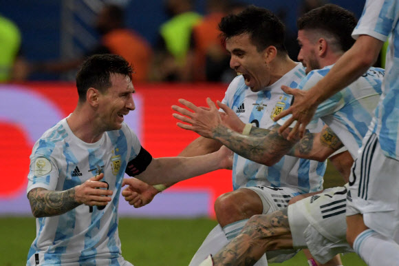 아르헨티나 축구 대표팀의 리오넬 메시(왼쪽)가 11일(한국시간) 브라질 리우데자네이루의 마라카낭에서 열린 브라질과의 2021 코파 아메리카 결승전에서 1-0으로 승리한 후 동료와 함께 기쁨을 나누고 있다.  리우데자네이루 AFP 연합뉴스