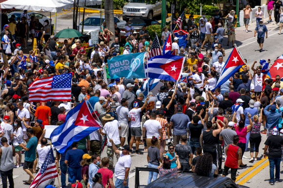 쿠바에서 반정부 시위가 열린 11일(현지시간) 미국 플로리다주 마이애미의 쿠바인 거주지 리틀 아바나의 시민들이 쿠바기와 미국 성조기를 나눠 들고 연대 시위에 나서고 있다. 마이애미 AP 연합뉴스