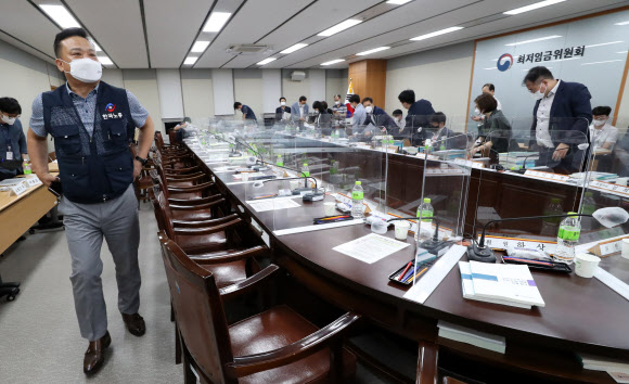 최저임금위원회 근로자위원인 이동호 한국노총 사무총장(왼쪽)이 12일 세종시 정부세종청사 최저임금위원회 회의실에서 열린 제9차 전원회의를 마친 뒤 회의장을 나서고 있다.  이날 전원회의에서는 사용자 위원 전원과 민주노총 소속 위원들이 퇴장했지만 한국노총은 퇴장하지 않았다. 내년도 최저임금은 9천160원으로 결정됐다. 2021.7.13  연합뉴스