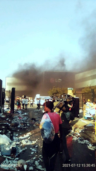 남아프리카공화국에서 제이콥 주마 전 대통령의 구금에 항의하는 시위와 함께 촉발된 대규모 폭동과 약탈이 수도권까지 번지고 있는 가운데 동남부 항구도시 더반에 있는 LG전자 공장이 불에 타는 등 우리 기업도 큰 피해를 봤다. 12일 군중에 의해 불타고 약탈당하는 더반 LG전자 공장. 2021.7.13  연합뉴스