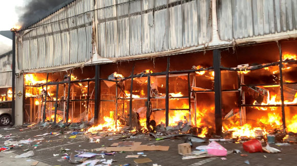 13일(현지시간) 폭동이 일주일째 이어지고 있는 남아프리카공화국 나탈주 피터마리츠버그의 한 상점 건물이 불타는 모습. 피터마리츠버그 로이터 연합뉴스