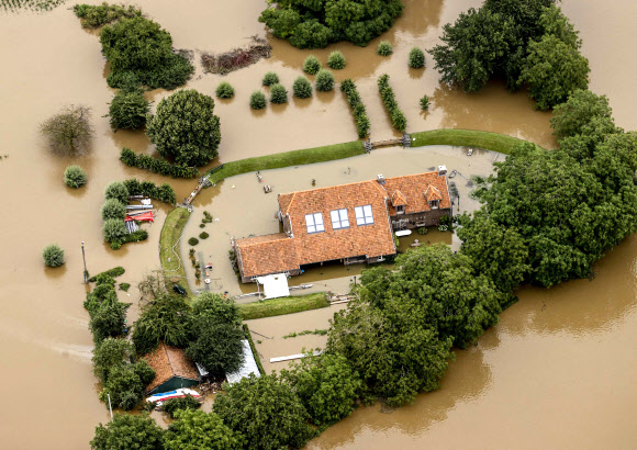 This aerial view taken in Valkenburg on July 16, 2021 shows the flooded area around the Meuse. - The death toll from devastating floods in Europe soared to at least 126 on July 16, 2021, most in western Germany where emergency responders were frantically searching for missing people. In Belgium, the government confirmed the death toll had jumped to 20 - earlier reports had said 23 dead - with more than 21,000 people left without electricity in one region. (Photo by Remko de Waal / ANP / AFP) / Netherlands OUT/2021-07-17 06:03:34/ <연합뉴스