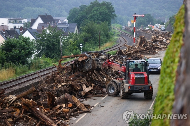 17일(현지시간) 독일 폭우 피해 지역 도로에서 나무 등을 치우는 작업이 진행되고 있다. [로이터=연합뉴스]