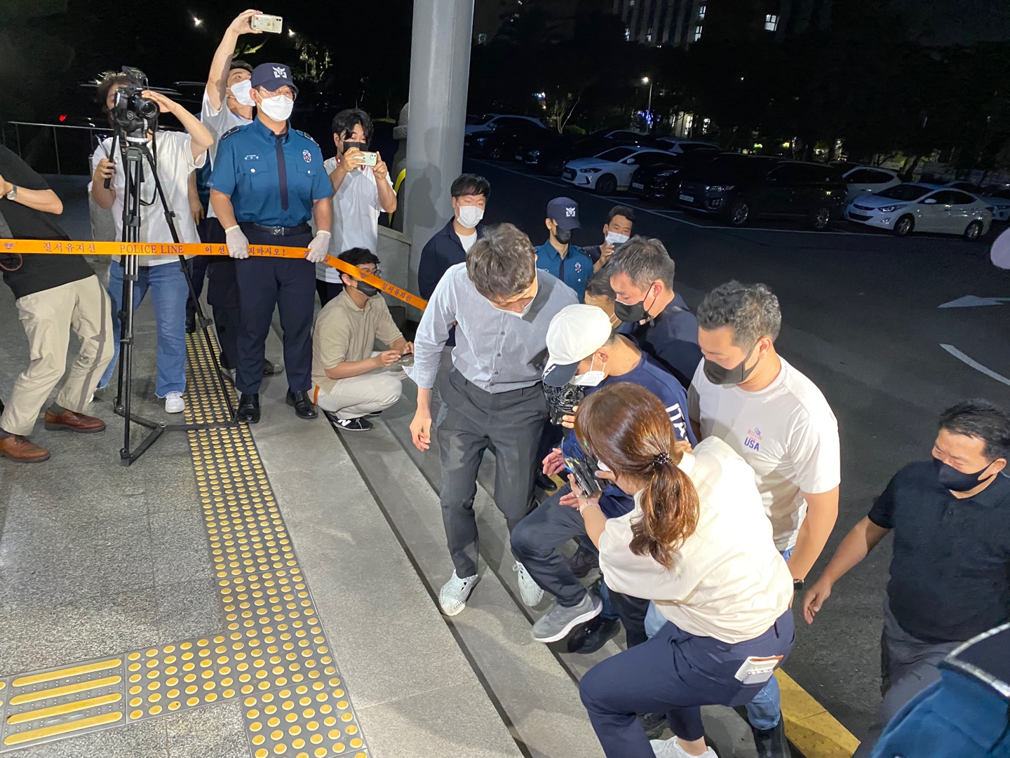 지난 19일 오후 제주동부경찰서에서 지인의 10대 아들을 살해한 혐의로 경찰에 붙잡힌 40대(가운데 모자 쓴 이) A씨가 취재진 질문을 받고 있다.