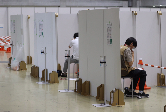 2020도쿄올림픽 메인프레스센터(MPC)에서 취재진이 PCR 검사를 위해 자신의 타액을 모으고 있다. 올림픽 취재진은 취재영역에 따라 매일 혹은 3일에 한 번씩 PCR 검사에서 음성을 받아야 각 경기장에 출입할 수 있다.