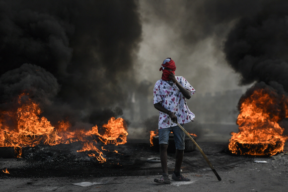22일 암살된 조브넬 모이즈 대통령에 대한 정의를 요구하는 시위대가 아이티 캡-아이티엔의 불타는 바리케이드 근처에 서 있다.2021.7.23 사진=AP