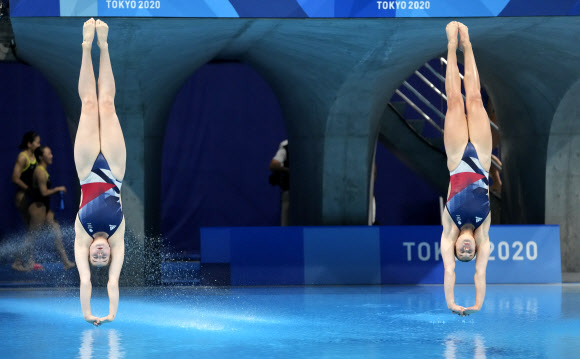 영국의 그레이스 리드와 캐서린 토랜스가 25일(현지시간) 일본 도쿄 아쿠아틱스 센터에서 열린 2020년 하계 올림픽 여자 싱크로나이즈드 3m 스프링보드 결승에서 멋진 연기를 펼치고 있다. AP 연합뉴스