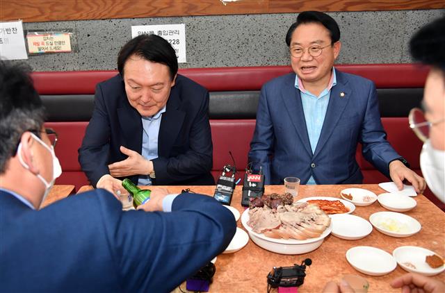 야권 대권주자인 윤석열 전 검찰총장이 27일 부산 서구의 한 식당을 방문, 지역 국회의원들과 함께 식사하면서 소주잔을 채우고 있다. 2021.7.27 뉴스1