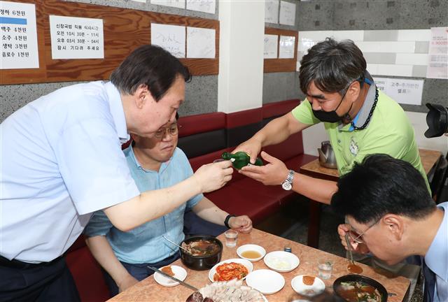 야권 대권주자인 윤석열 전 검찰총장이 27일 부산 서구의 한 식당을 방문, 지역 국회의원들과 함께 식사하던 중 시민이 권하는 소주를 받고 있다. 2021.7.27 뉴스1
