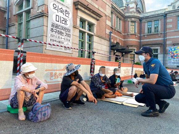 서울역파출소 박아론(오른쪽) 경위가 지난 22일 서울역 노숙인들과 함께 이야기를 나누고 있다.