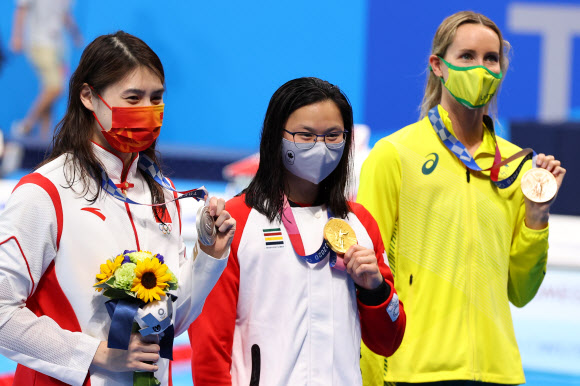 26일 2020 도쿄올림픽 여자 100m 접영 시상대에서 캐나다 마가렛 맥닐(가운데) 선수가 은메달을 딴 중국 장위페이(왼쪽) 선수와 나란히 서 있다. 로이터 연합뉴스