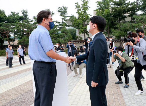국민의당 안철수 대표(오른쪽)가 29일 오전 서울 종로구 청와대 사랑채 앞에서 ‘드루킹 댓글 사건’ 관련 1인 시위를 벌이고 있는 국민의힘 정진석 의원을 지지 방문해 악수하고 있다. 2021.7.29  연합뉴스