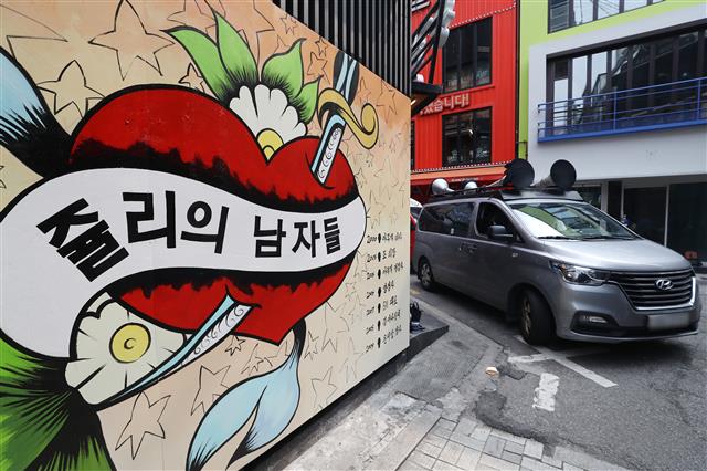 29일 서울 종로구의 한 서점 벽면에 그려진 윤석열 전 검찰총장의 배우자 김건희 씨를 비방하는 내용의 벽화를 보수단체 관계자들이 차량으로 막아서고 있다. 앞서 지난달 김건희씨는 자신이 ‘강남 유흥주점의 접객원 쥴리였다’는 루머에 대해 “누가 소설을 쓴 것”이라고 해명했다. 윤석열 대선 예비후보 캠프는 지난 27일 김건희에 대한 루머가 확산되고 있는 것에 강력히 대응하겠다고 밝혔다. 2021.7.29 뉴스1