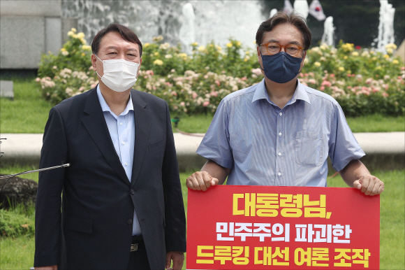 범야권 대선주자인 윤석열 전 검찰총장이 29일 오전 서울 종로구 청와대 앞 분수대 광장에서 드루킹 댓글 조작 사건과 관련해 문재인 대통령의 사과를 촉구하며 1인 시위를 하고 있는 정진석 국민의힘 의원을 격려 방문해 발언을 하고 있다. 2021. 7. 29  김명국 선임기자 daunso@seoul.co.kr