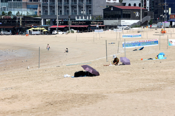 29일 오전 인천 중구 을왕리 해수욕장이 한산한 모습을 보이고 있다. 사회적 거리두기 4단계 격상으로 중구 해수욕장인 을왕리, 왕산, 하나개, 실미 등 4개소가 임시 폐장했다. 그러나 입장 자체가 금지된 것은 아니라 행락객들을 볼 수 있었다. 2021.7.29  연합뉴스