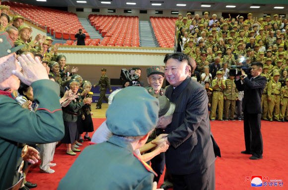 김정은 북한 국무위원장이 지난 29일 제7차 전국노병대회 참가자들과 만나고 기념사진을 촬영했다고 조선중앙통신이 30일 보도했다. 2021.7.30  평양 조선중앙통신 연합뉴스