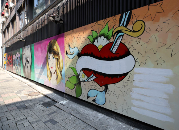 서울 종로구의 한 서점 외벽에 그려진 대권 주자 윤석열 예비후보의 부인 김건희 씨를 비방하는 내용의 벽화가 논란이 되고 있는 가운데 30일 오전 한 건물 관계자가 벽화의 글자를 흰색 페인트로 칠해 모두 지웠다. 2021.7.30  연합뉴스