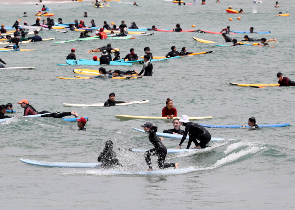 폭염이 이어진 30일 오후 부산 송정해수욕장을 찾은 서퍼들이 서핑을 즐기고 있다. 2021.7.30  연합뉴스