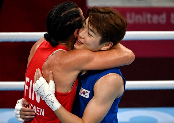 30일 일본 코쿠기칸(國技館)에서 열린 도쿄올림픽 여자 복싱 라이트급 16강전이 끝난 뒤 한국의 오연지(오른쪽)와 핀란드의 미라 포트코넨이 포옹을 하고 있다. AFP 연합뉴스