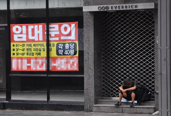 코로나 19의 여파로 경제가 얼어붙은 가운데 1일 서울 종로의 한 공실건물 옆에서 노숙인이 지친표정으로 앉아 있다. 2021.8.1 박지환기자 popocar@seoul.co.kr