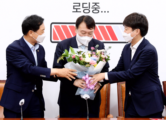 이준석 국민의힘 대표(오른쪽)와 김기현 원내대표(왼쪽)가 2일 오전 서울 여의도 국회를 찾은 윤석열 국민의힘 대선 예비후보에게 입당을 축하하는 꽃다발을 전달하고 있다.2021. 8. 2 김명국 선임기자 daunso@seoul.co.kr