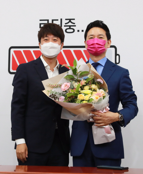 이준석 국민의힘 대표가 2일 서울 여의도 국회에서 열린 장성민 전 의원 입당 환영식에서 장 전 의원에게 꽃다발을 전달한 뒤 기념촬영을 하고 있다. 2021. 8. 2 김명국 선임기자 daunso@seoul.co.kr