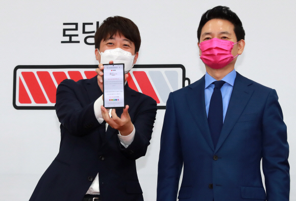 이준석 국민의힘 대표가 2일 오전 서울 여의도 국회에서 열린 장성민 전 의원 입당 환영식에서 장 전 의원의 스마트폰 입당신청 화면을 들어보이고 있다. 장 전 의원은 김대중 정부 시절 국정상황실장 등을 맡았다. 2021. 8. 2 김명국 선임기자 daunso@seoul.co.kr