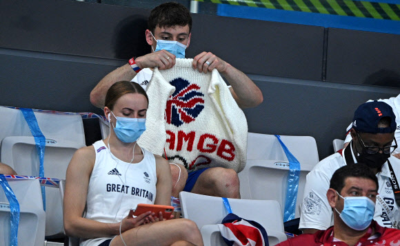 영국 다이빙 선수 톰 데일리가 2일 2020 도쿄 올림픽 관중석에서 뜨개질을 하고 있다. AFP 연합뉴스