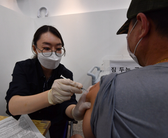 3일 서울 용산구청에 마련된 접종센터를 찾은 시민들이 코로나19 예방접종주사를 맞고 있다. 2021.8.3 박지환기자 popocar@seoul.co.kr