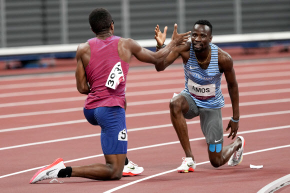 지난 1일 도쿄올림픽 육상 남자 800m 준결승전에서 아이자이어 주잇(미국)과 니젤 아모스(보츠와나)가 넘어진 뒤 일어나 서로 손을 맞잡으려는 모습. AP