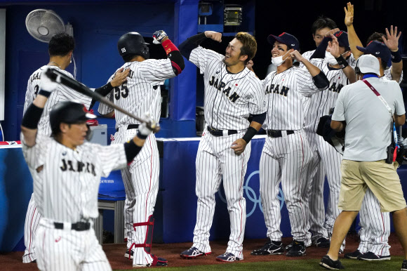 일본 야구 대표팀 선수들이 7일 일본 가나가와 요코하마 스타디움에서 열린 도쿄올림픽 야구 결승에서 무네타카 무라카미가 홈런을 치고 더그아웃에 들어오자 기쁘게 맞아주고 있다. 요코하마 AP