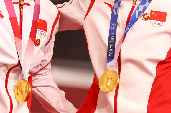 지난 2일 일본 시즈오카현의 이즈 벨로드롬에서 열린 2020 도쿄올림픽 사이클 여자 단체 스프린트 금메달을 목에 건 바오샨주(왼쪽)와 종톈시(이상 중국)의 가슴에 마오쩌둥 배지가 눈에 띄는데 다음날 로이터 통신이 배지 부분을 더 선명하게 볼 수 있도록 트리밍해 다시 전송했다. 로이터 자료사진 연합뉴스 
