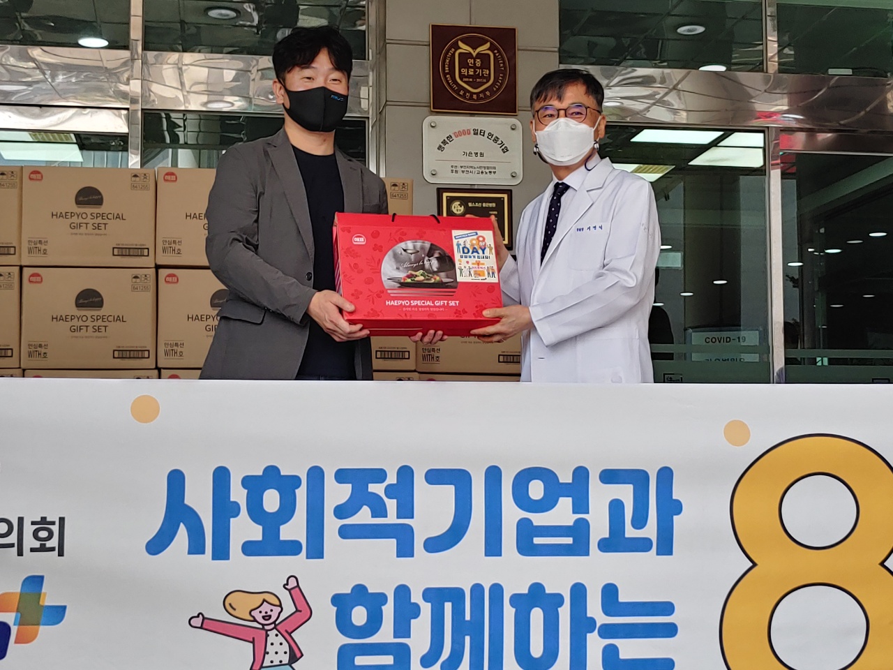김승모(왼쪽) 부천사회적기업협의회 회장이 기평석 가은병원장에게 코로나19로 힘든 의료진들을 위해 ‘기프트 박스’를 전달하고 있다.
