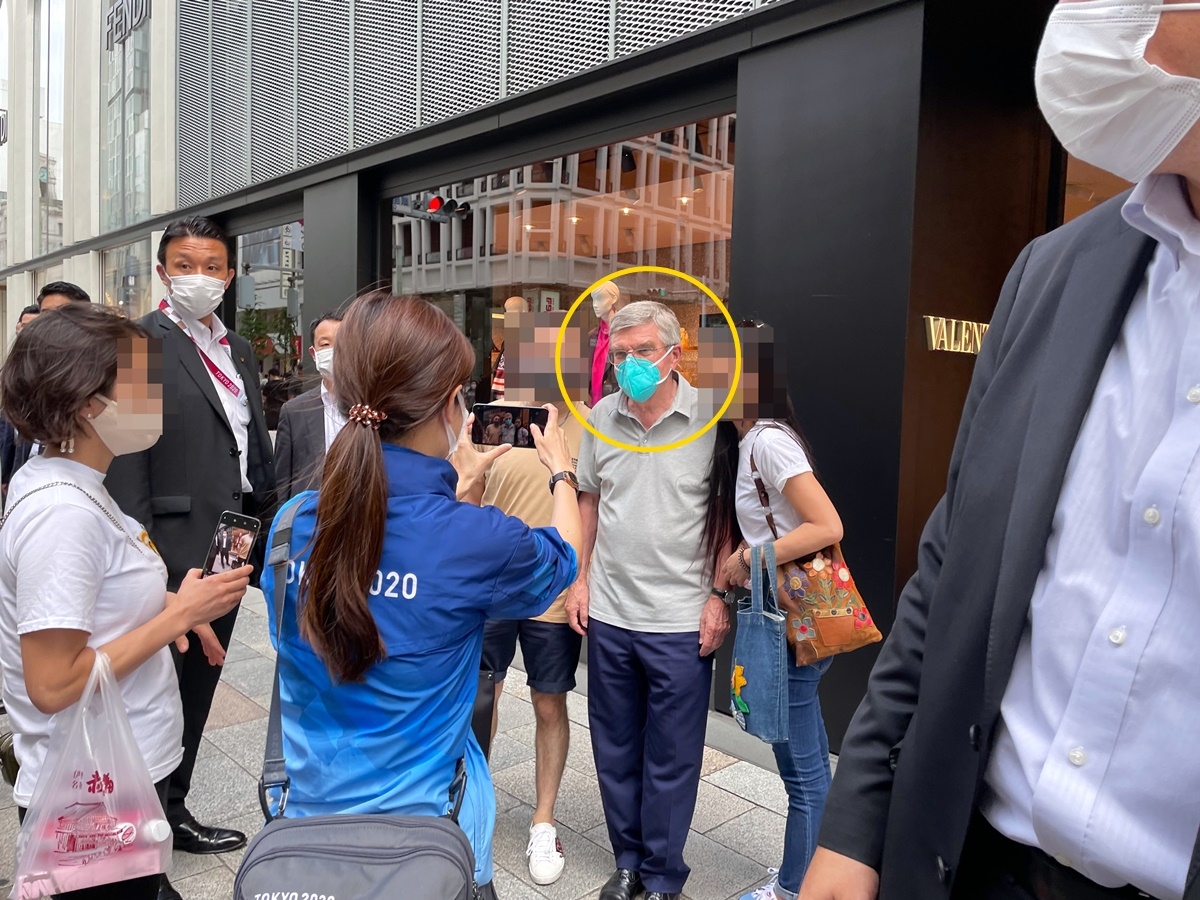 토마스 바흐 IOC 위원장으로 추정되는 인물(노란 원)이 9일 일본 도쿄 번화가 긴자 거리에서 시민들과 사진을 찍어주는 모습.  트위터
