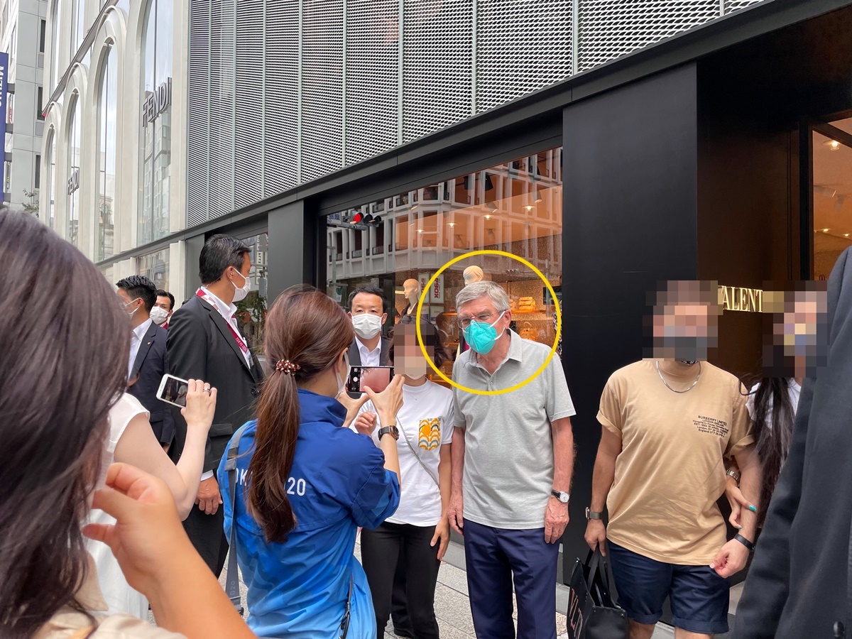 토마스 바흐 IOC 위원장으로 추정되는 인물(노란 원)이 9일 일본 도쿄 번화가 긴자 거리에서 시민들과 사진을 찍어주는 모습. 바흐 위원장 추정 남성 오른쪽의 남녀와 함께 사진을 찍은 뒤 기다리고 있던 다른 여성과 사진을 찍고 있다.   트위터