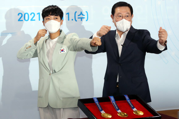 11일 광주시청 소회의실에서 2020 도쿄올림픽 양궁 3관왕에 오른 안산(왼쪽) 선수와 이용섭 광주시장이 여자 양궁 단체전 금메달 수상 당시 ‘활시위 세리머니’를 재연하고 있다. 안산은 이날 광주시 명예홍보대사에 위촉됐다. 2021.8.11  연합뉴스