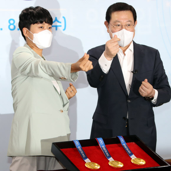 11일 광주시청 소회의실에서 2020 도쿄올림픽 양궁 3관왕에 오른 안산(왼쪽) 선수와 이용섭 광주시장이 여자 양궁 단체전 금메달 수상 당시 ‘하트 세리머니’를 재연하고 있다. 안산은 이날 광주시 명예홍보대사에 위촉됐다. 2021.8.11  연합뉴스