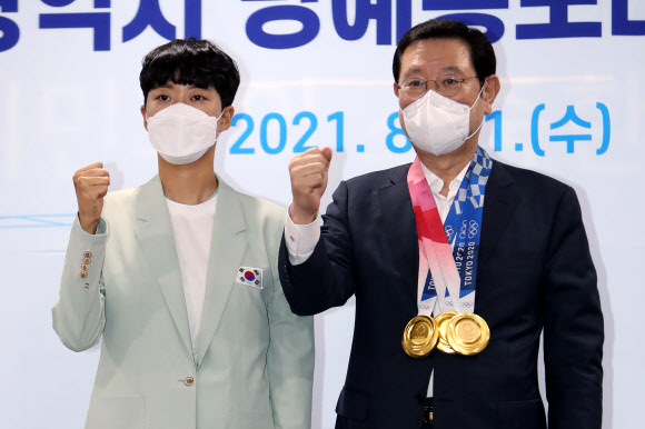 11일 광주시청 소회의실에서 2021 도쿄올림픽 양궁 3관왕에 오른 안산(왼쪽) 선수가 이용섭 광주시장에게 금메달을 걸어준 뒤 기념 촬영을 하고 있다. 안산은 광주시 명예홍보대사에 위촉됐다. 2021.8.11  연합뉴스