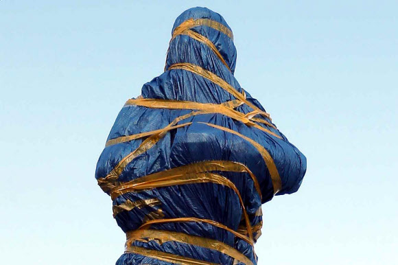 경남 창원시 마산합포구 중앙부두에 3·15 부정선거를 규탄하는 시위에 참여했다 얼굴에 최루탄이 박혀 숨진 채 마산만에 떠오른 김주열 열사 동상이 동상 추모판 문구를 둘러싸고 지역 민주운동 단체가 대립하면서 완성되고도 비닐과 테이프로 꽁꽁 감겨 한 달째 서 있다. 사진은 지난 11일 오후 촬영. 2021.8.12  연합뉴스