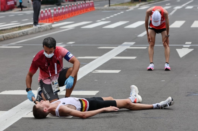 8일 일본 삿포로에서 열린 도쿄올림픽 마라톤 대회에 참가한 벨기에의 디에터 케르스텐 선수가 결승선을 들어온 뒤 바닥에 누워 치료받고 있다. /사진=AFP 연합뉴스
