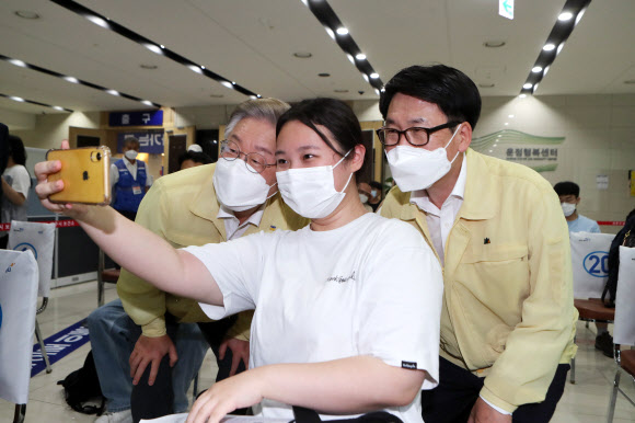 이재명 경기도지사(왼쪽)가 12일 경기도 파주시 운정 예방접종센터에서 백신 접종을 위해 센터를 찾은 수험생과 기념촬영하고 있다. 오른쪽은 최종환 파주시장. 2021.8.12  연합뉴스